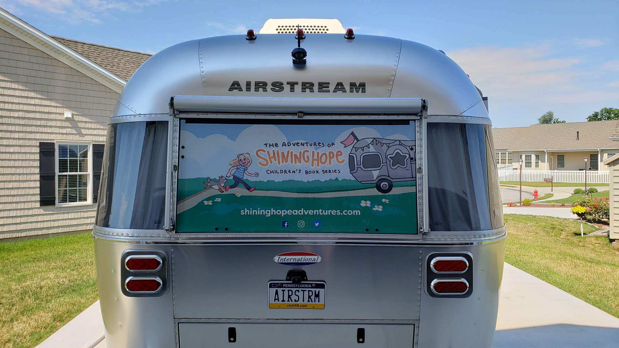 back of Airstream with shining hope childrens book on window